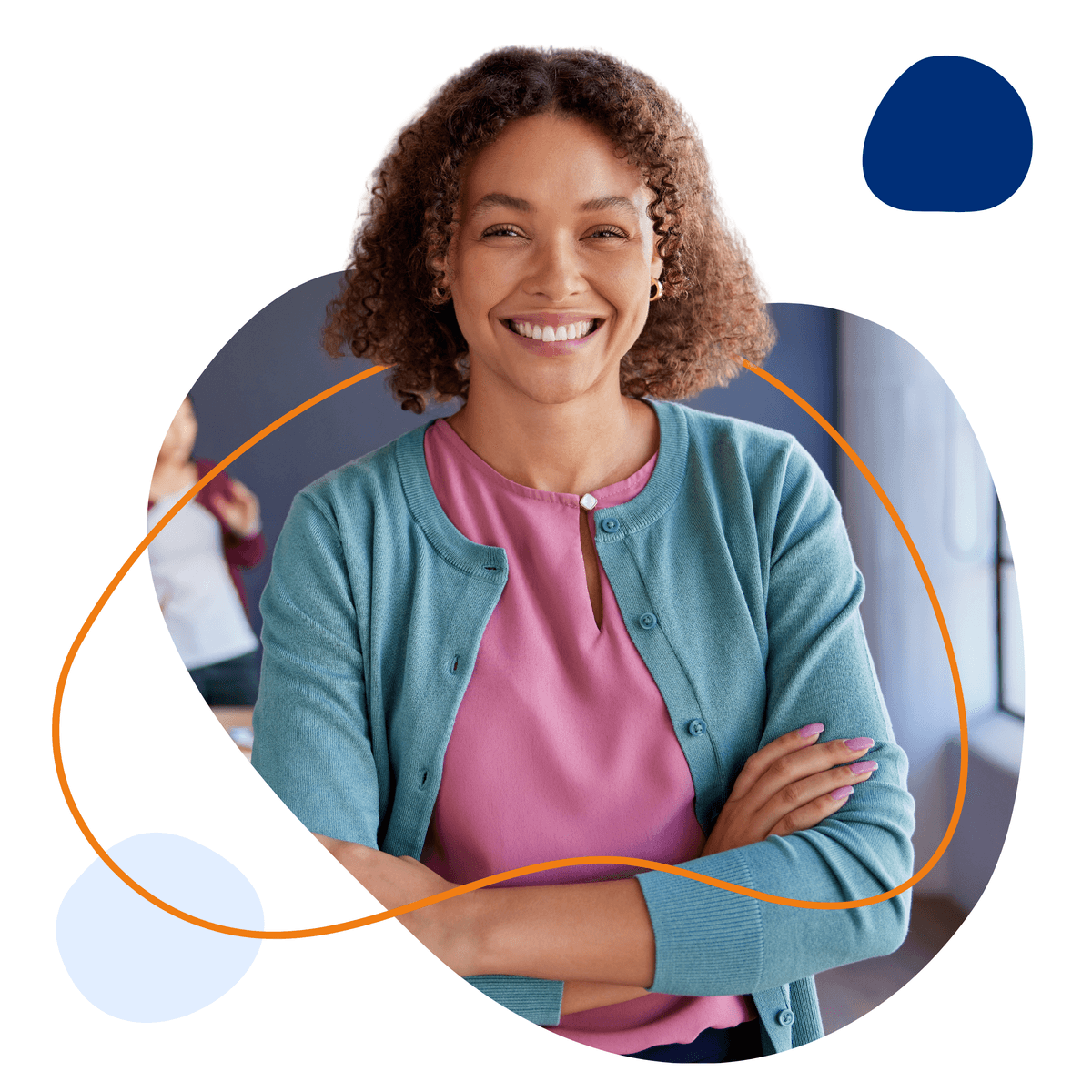 Fröhliche Erzieherin mit lockigem Haar und verschränkten Armen lächelt in die Kamera.